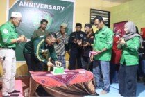 POTONG - Ketua Komunitas Bonek Timika saat memotong kue ulang tahun. (Foto: Mujiono/Seputarpapua)