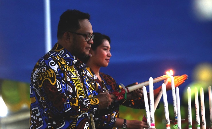Pj Bupati Mappi Michael R. Gomar saat menyalakan lilin pada Natal bersama, Kamis (29/12/2022). (Foto: Ist)