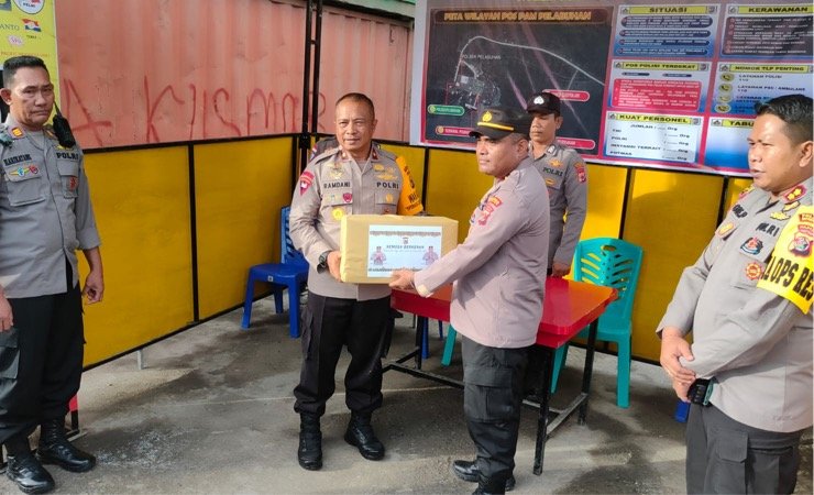 Wakapolda Papua, Brigjen Pol Ramdani Hidayat menyerahkan bingkisan kepada Kapolsek Kawasan Pelabuhan Poumako, Ipda W. Rumere usai meninjau pos pengamanan Operasi Lilin Cartenz 2022 di kawasan pelabuhan Poumako, Mimika, Papua Tengah, Selasa (27/12/2022). (Foto: Saldi/Seputarpapua)