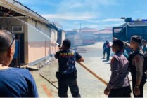 Petugas kepolisian setempat saat membantu melakukan proses pemadaman bangunan THM yang terbakar pada Kamis, 2 Februari 2023 di Kota Jayapura, Papua. (Foto: Humas Polda Papua)