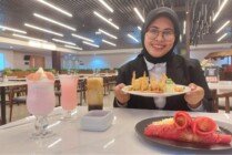 Caption: Public Relation Hotel Horison-Diana Mimika Rizky Wijanarko Putri saat memegang menu Prawn Roll Vermicelli, di Santan Resto, Hotel Horison-Diana Mimika, Senin (6/2/2023). (Foto: Fachruddin Aji/Seputarpapua)