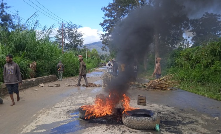 Rumah tergenang air, warga Honelama, Distrik Wamena, Jayawijaya, Papua Pegunungan melakukan aksi blokade jalan dengan membakar ban bekas. Mereka menuntut pemerintah setempat memperbaiki saluran air diwilayah itu, Senin (13/3/2023). (Foto: Amin Momiage/Seputarpapua)