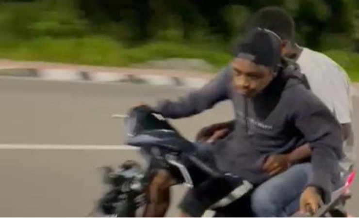 Seorang pemuda beraksi mengemudikan sepeda motor sambil memegang pisau mengancam pengendara lain di Jalan W.R Soepratman Timika, Mimika, Papua Tengah. (Foto: Tangkapan layar video viral)