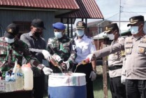 Polres Asmat bersama para pihak terkait termasuk Pemerintah Kabupaten Asmat, Papua Selatan, melakukan pemusnahan berbagai jenis minuman keras beralkohol hasil razia jajaran Polres Asmat, Selasa (21/3/2023). (Foto: Dok Humas Polres Asmat)