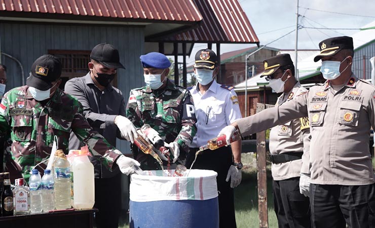 Polres Asmat bersama para pihak terkait termasuk Pemerintah Kabupaten Asmat, Papua Selatan, melakukan pemusnahan berbagai jenis minuman keras beralkohol hasil razia jajaran Polres Asmat, Selasa (21/3/2023). (Foto: Dok Humas Polres Asmat)