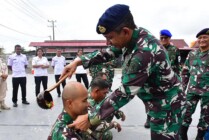 Danlanal Timika Letkol Apriles menyiram air kembang kepada prajurit TNI yang naik pangkat, Senin (3/4/2023). (Foto: Pen Lanal Timika)