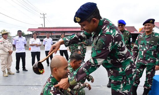 Danlanal Timika Letkol Apriles menyiram air kembang kepada prajurit TNI yang naik pangkat, Senin (3/4/2023). (Foto: Pen Lanal Timika)