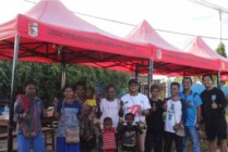 Pj Bupati Mappi saat ikut menyerahkan dan memasang tenda bagi para pedagang di Pasar Lilin, Kabupaten Mappi. (Foto: Humas Mappi)