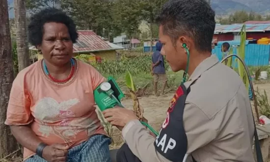 Seorang polisi memeriksa kesehatan warga dalam pengobatan gratis yang dilakukan di Kampung Ilambet, Puncak, Papua Tengah. (Foto: Humas Polda Papua)