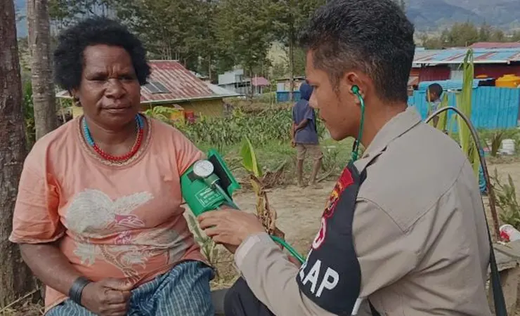 Seorang polisi memeriksa kesehatan warga dalam pengobatan gratis yang dilakukan di Kampung Ilambet, Puncak, Papua Tengah. (Foto: Humas Polda Papua)