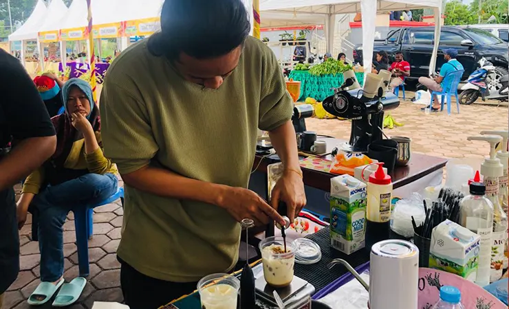 Aksa saat menyiapkan kopi untuk pelanggan pada Festival Produk UMKM, Sabtu (22/7/2023). (Foto: Anya Fatma/Seputarpapua)