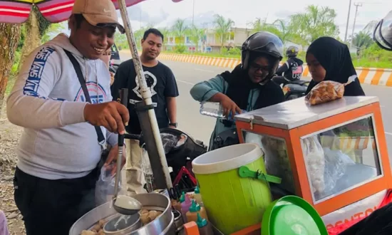 JUALAN | Mas Udin melayani pelanggan yang membeli pentolan. (Foto: Anya Fatma/Seputarpapua)