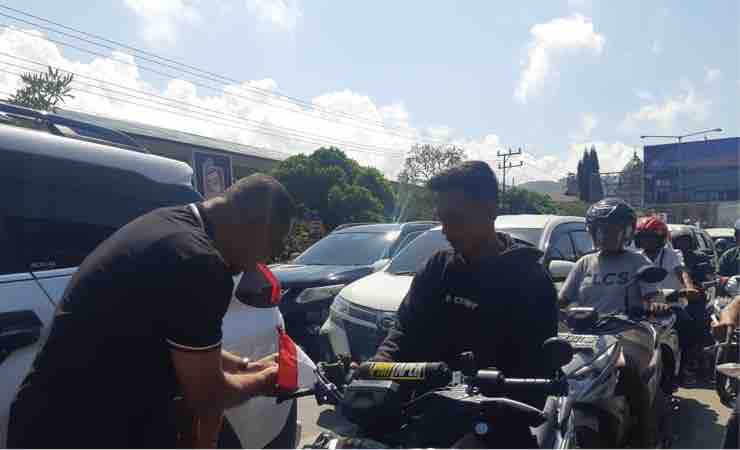 Pj Bupati Jayapura Triwarno ikut membagikan bendera merah putih. (Foto: Musa/ Seputarpapua)