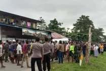 Mobil ambulans yang membawa jenazah korban dari RSUD Mimika tiba di lokasi blokade jalan depan Kompi A Senapan Yonif 757/GV, sempat ditahan dan meminta agar terduga pelaku mengangkat jenazah korban dan dibawa ke rumah duka. (Foto: Arifin Lolialang/Seputarpapua)