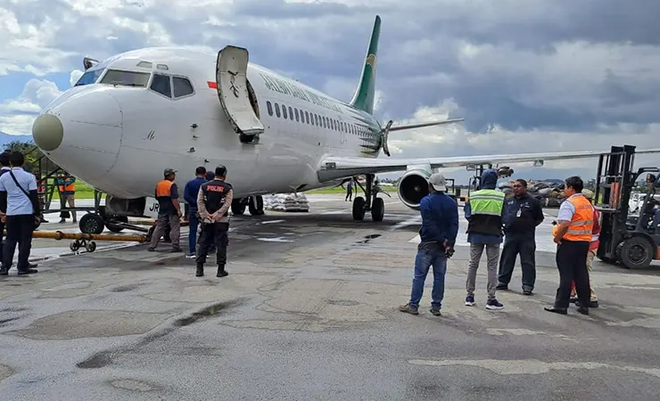 Suasana proses penarikan Pesawat Cargo Boeing seri 1200 Jayawijaya Air dengan nomor registrasi PK-JRA mengalami kebocoran pada ban depan akhirnya berhenti ditengah bandara Wamena (Foto: Humas Polda Papua)