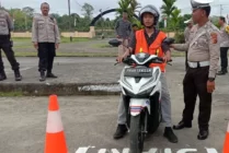 Petugas Satlantas Polres Mimika saat menjelaskan aturan ujian praktek SIM C kepada salah satu warga yang akan mengurus SIM. (Foto: Arifin Lolialang/Seputarpapua)