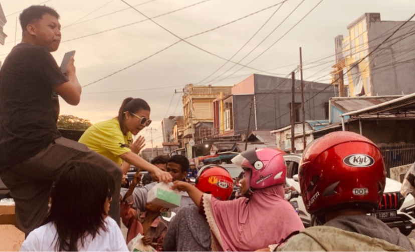 Terlihat Ci Wenda dan timnya saat membagikan takjil kepada masyarakat yang melintas dengan kendaraan maupun yang tengah duduk di emperan jalan. (Foto: Yandri/Seputarpapua)