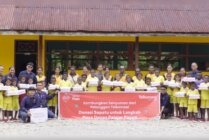 Foto bersama pihak Telkomsel dengan sejumlah murid pada salah satu sekolah di Timika. (Foto: Corcom Telkomsel)