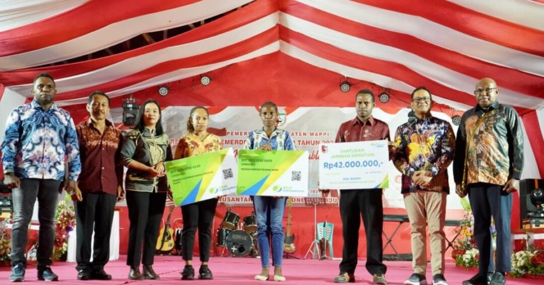 Foto bersama Pj Bupati Mappi, Michael R. Gomar bersama penerima kartu kepesertaan BPJS Ketenagakerjaan. (Foto: Dok Pemkab Mappi)