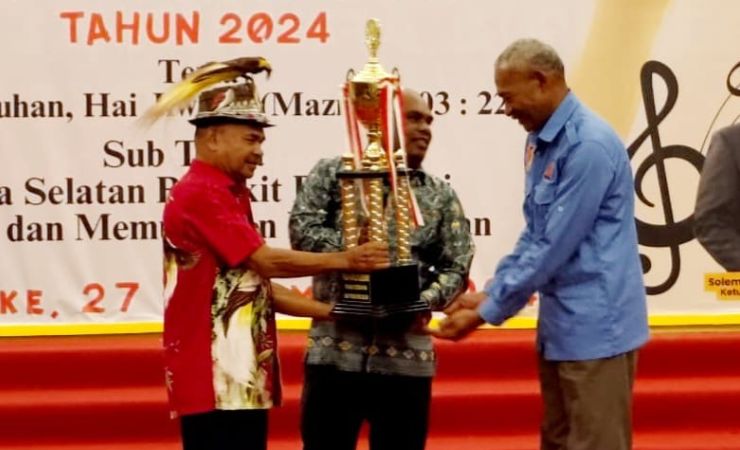 Penyerahan trofi juara umum Pesparawi XIV Se-Tanah Papua Tingkat Provinsi Papua Selatan oleh Sekda Merauke Yeremias Ndiken kepada Ketua LPPD Boven Digoel, Yonas Jambormias. (Foto: Hendrik/Seputarpapua)