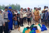 Ipda Jamiludin saat mewakili Kapolres Mimika AKBP I Komang Budiartha saat menyerahkan bantuan bahan makanan kepada warga tiga kampung yang mengungsi akibat penyerangan Kampung Wakia. (Foto: Humas Polres Mimika)