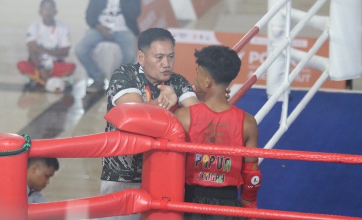 Pelatih Kepala Tim Muay Thai Papua Tengah, Jones Ayorbaba saat memberikan semangat kepada Huwal Putra Howay ketika berlaga di partai semifinal 54 Kg melawan tuan rumah Aceh. (Foto: Saldi/Seputarpapua)