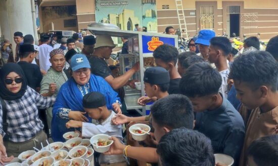 Ny Erda Rombe saat melakukan aksi Jumat Berkah di Jalan Bhayangkara, Jumat (18/10/2024). (Sumber foto: Media AIYE)