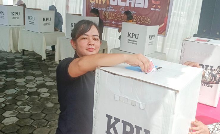 Salah satu warga memasukkan surat suara ke dalam kotak pada saat simulasi penghitungan dan pemungutan suara (Tungsura) yang digelar KPU Mimika. (Foto: Mujiono/Seputarpapua)