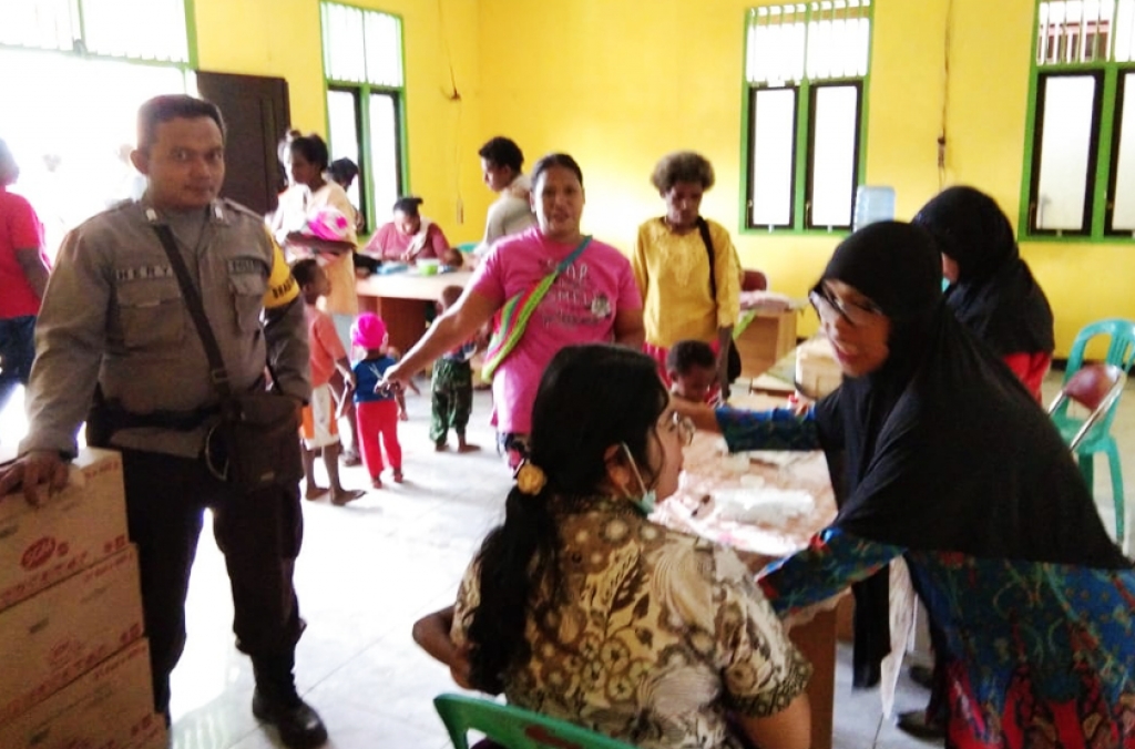 Di Merauke, Bhabinkamtibmas Dampingi Petugas Puskesmas Berikan Vaksin MR 